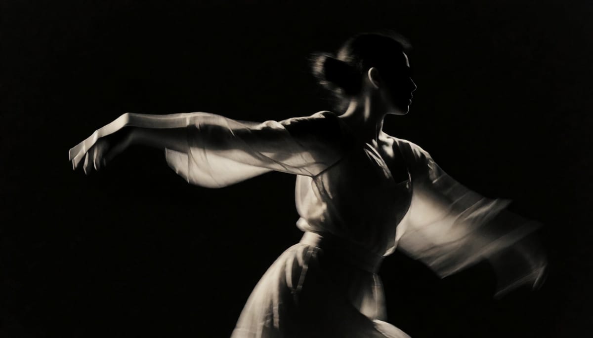 Close-up of a dancer mid-motion under hard key light, motion blur trailing from an outstretched arm