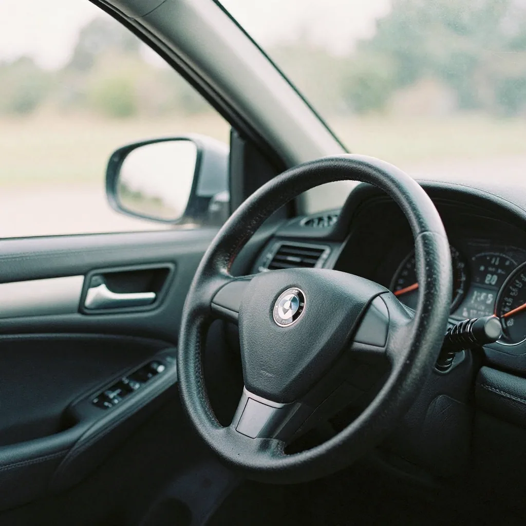 Interior shot from the passenger side showing the steering wheel and gauge cluster, soft daylight through the windshield