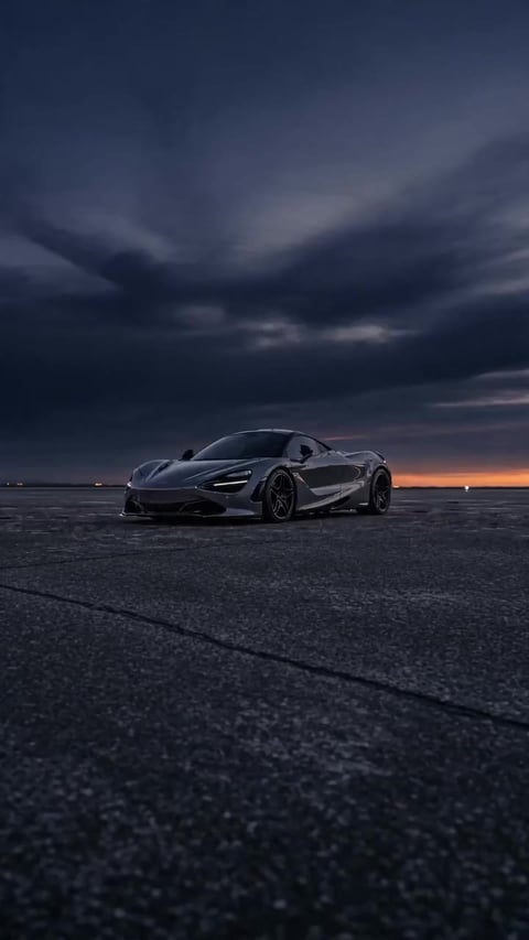A frame from a low-angle launch car reel generated by the Imagera Car Reel Maker — an aggressive front 3/4 push-in at dusk, built from a single car photo