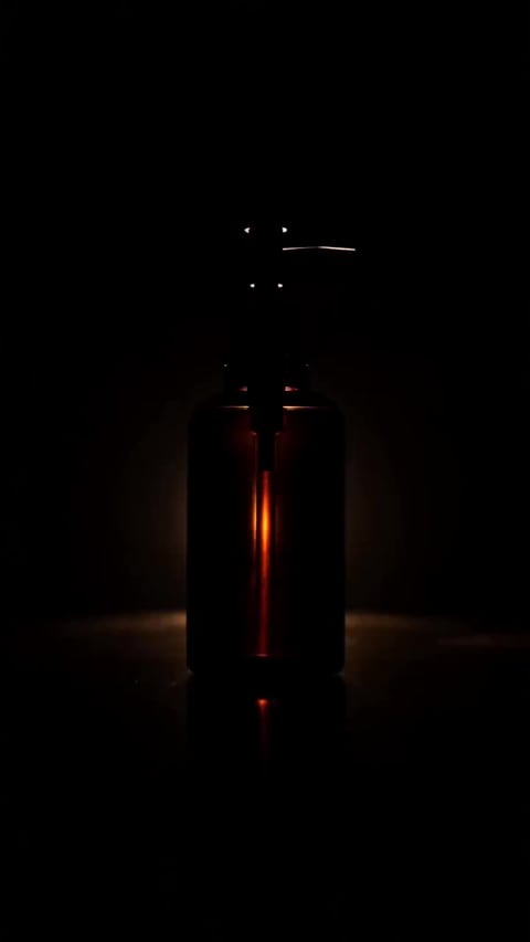 A frame from a Dramatic Reveal product reel generated by the Imagera Product Reel Maker — the product emerging from shadow with a slow push-in, built from the same product photo